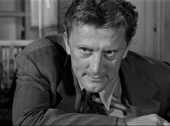 Movie still from “Detective Story” (1951), directed by William Wyler – A man wearing a suit and tie looking at the camera; Close Up shot, Low angle