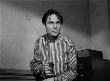 Movie still from “Detective Story” (1951), directed by William Wyler – A black and white photo of a man holding a gun; Close Up shot, Low angle