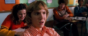 Movie still from “Detroit Rock City” (1999), directed by Adam Rifkin – A young man in an orange and white checkered shirt; Close Up shot, Low angle