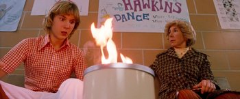 Movie still from “Detroit Rock City” (1999), directed by Adam Rifkin – Two women sitting in front of a fire in a room; Medium shot, Low angle