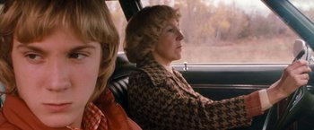 Movie still from “Detroit Rock City” (1999), directed by Adam Rifkin – A woman sitting in the back seat of a car with a child; Close Up shot, Over the shoulder angle