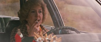 Movie still from “Detroit Rock City” (1999), directed by Adam Rifkin – A woman sitting in a car smoking a cigarette; Close Up shot, Over the shoulder angle