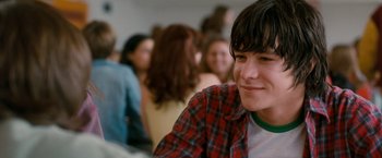 Movie still from “Detroit Rock City” (1999), directed by Adam Rifkin – A young man sitting in front of a group of people; Close Up shot, Over the shoulder angle