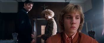 Movie still from “Detroit Rock City” (1999), directed by Adam Rifkin – A group of people standing in front of a cross; Close Up shot, Over the shoulder angle