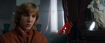 Movie still from “Detroit Rock City” (1999), directed by Adam Rifkin – A young woman in a room with red flowers and a window; Close Up shot, Over the shoulder angle