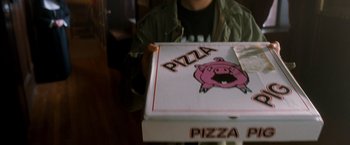 Movie still from “Detroit Rock City” (1999), directed by Adam Rifkin – A person sitting at a table holding a box of pizza; Extreme Close Up shot, High angle