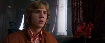 Movie still from “Detroit Rock City” (1999), directed by Adam Rifkin – A young man with blonde hair and a checkered shirt looking surprised; Close Up shot, Low angle