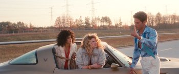 Movie still from “Detroit Rock City” (1999), directed by Adam Rifkin – A couple of women sitting in the back of a car; Wide shot, Over the shoulder angle