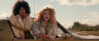 Movie still from “Detroit Rock City” (1999), directed by Adam Rifkin – A woman with curly hair sitting in the back seat of a car; Close Up shot, Low angle