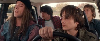 Movie still from “Detroit Rock City” (1999), directed by Adam Rifkin – A couple of people that are sitting in a car; Close Up shot, Over the shoulder angle