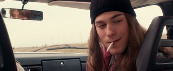 Movie still from “Detroit Rock City” (1999), directed by Adam Rifkin – A man sitting in a car with a cigarette in his mouth; Close Up shot, Overhead angle