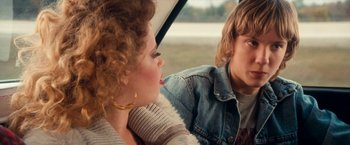 Movie still from “Detroit Rock City” (1999), directed by Adam Rifkin – A woman and a man sitting next to each other; Close Up shot, Over the shoulder angle