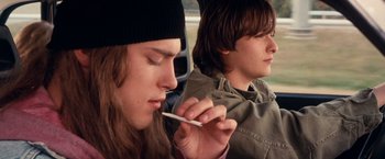 Movie still from “Detroit Rock City” (1999), directed by Adam Rifkin – Two young men sitting in the back seat of a car; Medium shot, Low angle