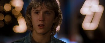 Movie still from “Detroit Rock City” (1999), directed by Adam Rifkin – A person with long blonde hair; Close Up shot, Over the shoulder angle