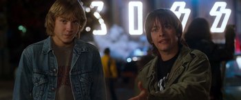 Movie still from “Detroit Rock City” (1999), directed by Adam Rifkin – Two young men standing next to each other on a city street; Medium shot, Over the shoulder angle