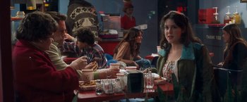 Movie still from “Detroit Rock City” (1999), directed by Adam Rifkin – A group of people sitting at a table eating food; Medium shot, Over the shoulder angle