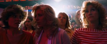Movie still from “Detroit Rock City” (1999), directed by Adam Rifkin – A woman standing in front of a group of people; Close Up shot, Low angle
