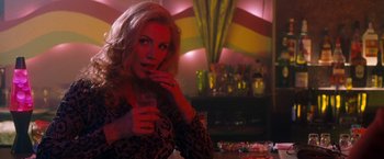 Movie still from “Detroit Rock City” (1999), directed by Adam Rifkin – A woman sitting at a table with a glass of wine; Medium shot, Over the shoulder angle