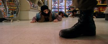 Movie still from “Detroit Rock City” (1999), directed by Adam Rifkin – A group of people laying on the ground in front of a store; Wide shot, High angle