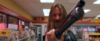 Movie still from “Detroit Rock City” (1999), directed by Adam Rifkin – A man with long hair holding a blow dryer in his hand; Close Up shot, Low angle