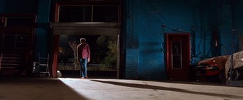 Movie still from “Detroit Rock City” (1999), directed by Adam Rifkin – A person standing in front of an open garage door; Wide shot, Over the shoulder angle