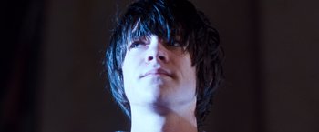 Movie still from “Detroit Rock City” (1999), directed by Adam Rifkin – A person's face with long black hair; Close Up shot, Low angle