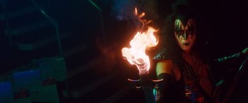 Movie still from “Detroit Rock City” (1999), directed by Adam Rifkin – A person is holding a flame in a dark room; Medium shot, High angle