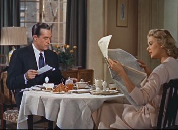 Movie still from “Dial M for Murder” (1954), directed by Alfred Hitchcock – A man and a woman sitting at a dinner table reading newspapers; Medium shot, High angle