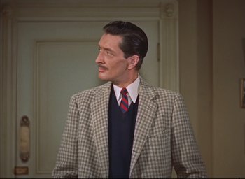 Movie still from “Dial M for Murder” (1954), directed by Alfred Hitchcock – A man in a suit and tie standing in front of a door; Medium shot, High angle