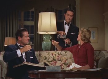 Movie still from “Dial M for Murder” (1954), directed by Alfred Hitchcock – A group of people sitting around a table with drinks; Medium shot, Low angle