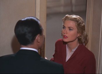 A man and a woman talking in front of a mirror