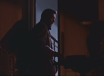 Movie still from “Dial M for Murder” (1954), directed by Alfred Hitchcock – A man standing in front of a window in a dark room; Medium shot, Low angle