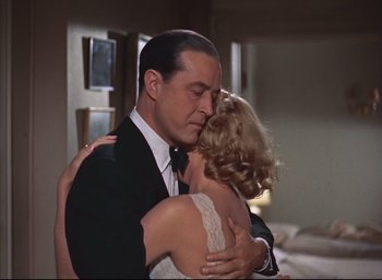 Movie still from “Dial M for Murder” (1954), directed by Alfred Hitchcock – A man and a woman embracing in a room; Medium shot, Low angle