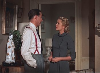 Movie still from “Dial M for Murder” (1954), directed by Alfred Hitchcock – A man and a woman standing next to each other in a room; Medium shot, Low angle