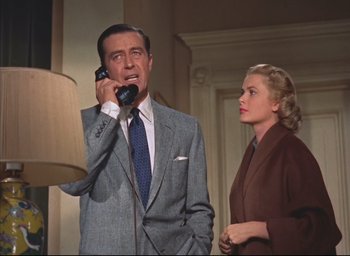 Movie still from “Dial M for Murder” (1954), directed by Alfred Hitchcock – A man and a woman standing next to each other; Medium shot, Low angle