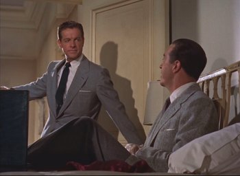 Movie still from “Dial M for Murder” (1954), directed by Alfred Hitchcock – Two men in suits sitting on a bed talking to each other; Medium shot, Low angle