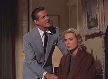 Movie still from “Dial M for Murder” (1954), directed by Alfred Hitchcock – A man and a woman in a room with a painting on the wall behind them; Medium shot, Over the shoulder angle