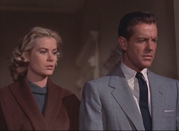 Movie still from “Dial M for Murder” (1954), directed by Alfred Hitchcock – A man and a woman standing next to each other; Medium shot, Low angle