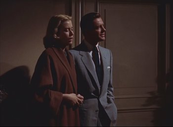 Movie still from “Dial M for Murder” (1954), directed by Alfred Hitchcock – A man and a woman standing next to each other; Medium shot, Low angle
