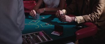 Movie still from “Diamonds Are Forever” (1971), directed by Guy Hamilton – A couple of people sitting at a table playing cards; Extreme Close Up shot, Overhead angle