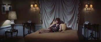 Movie still from “Diamonds Are Forever” (1971), directed by Guy Hamilton – A woman in lingerie sitting on top of a bed; Wide shot, High angle