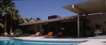 Movie still from “Diamonds Are Forever” (1971), directed by Guy Hamilton – A woman standing next to an outdoor swimming pool; Extreme Wide shot, Low angle