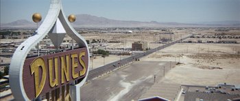 Movie still from “Diamonds Are Forever” (1971), directed by Guy Hamilton – An aerial view of an empty road with a sign on the side; Extreme Wide shot, High angle