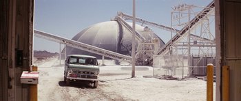 Movie still from “Diamonds Are Forever” (1971), directed by Guy Hamilton – A truck parked in front of a cement plant; Extreme Wide shot, High angle