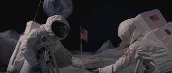 Movie still from “Diamonds Are Forever” (1971), directed by Guy Hamilton – Two people on the side of the moon holding a flag; Wide shot, Overhead angle