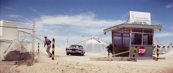 Movie still from “Diamonds Are Forever” (1971), directed by Guy Hamilton – A car parked in front of a building on the beach; Extreme Wide shot, Low angle