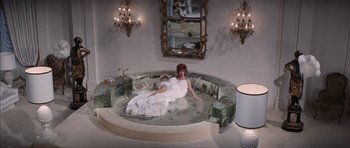 Movie still from “Diamonds Are Forever” (1971), directed by Guy Hamilton – A woman in a white dress laying in a bath tub; Wide shot, High angle