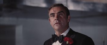 Movie still from “Diamonds Are Forever” (1971), directed by Guy Hamilton – A person wearing a suit and bow tie; Close Up shot, Low angle