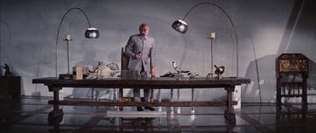 Movie still from “Diamonds Are Forever” (1971), directed by Guy Hamilton – A man standing in front of a dining room table; Wide shot, Low angle