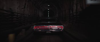 Movie still from “Diamonds Are Forever” (1971), directed by Guy Hamilton – A car is driving through a tunnel in the dark; Wide shot, Low angle